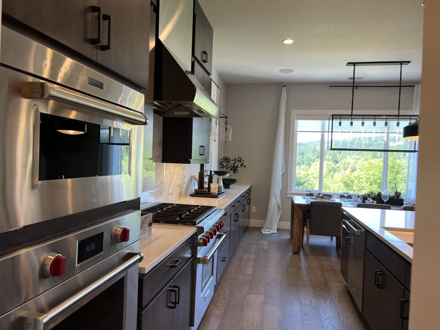 A kitchen with stainless steel appliances and wooden floors.