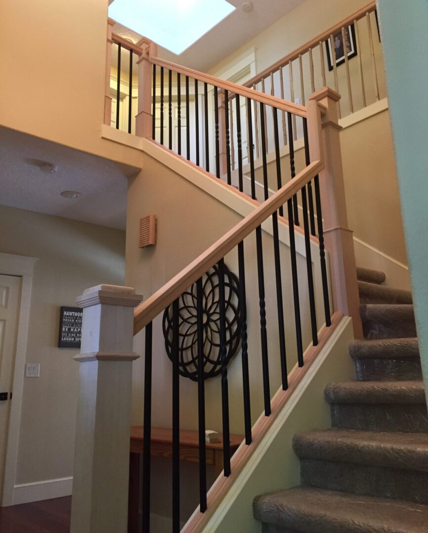 A staircase with wooden handrails and metal spindles.