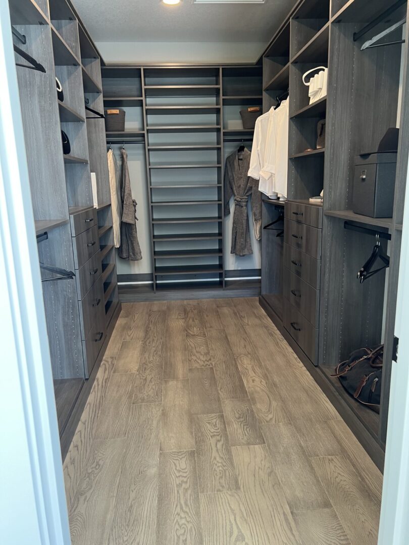 A walk in closet with many drawers and shelves.