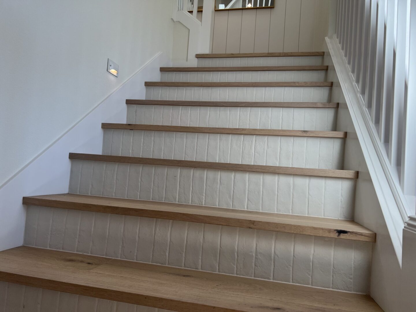 A staircase with wooden steps and white tiled risers.
