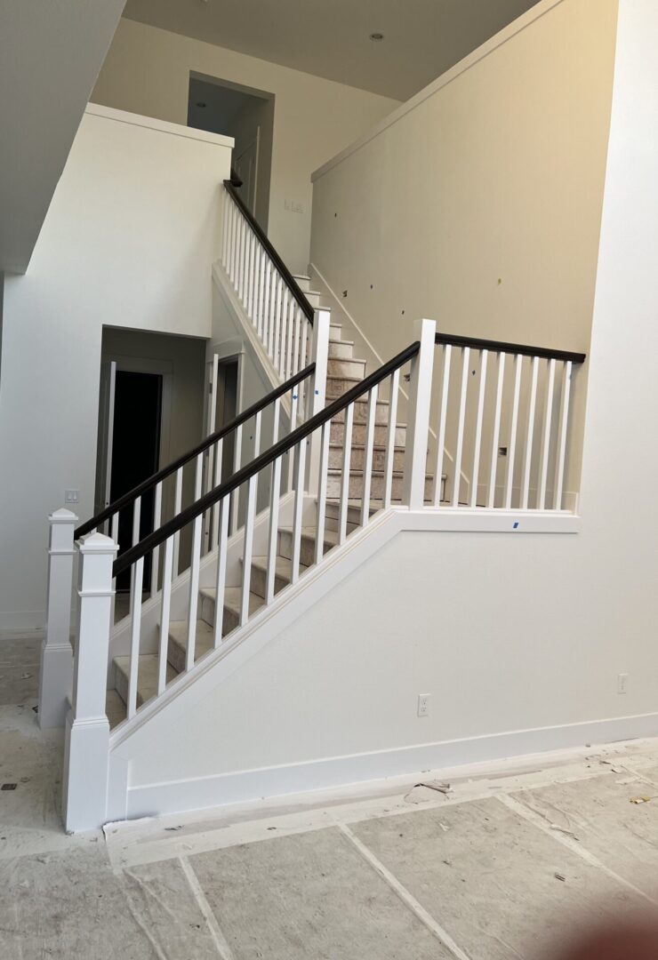 A white staircase with black handrail.