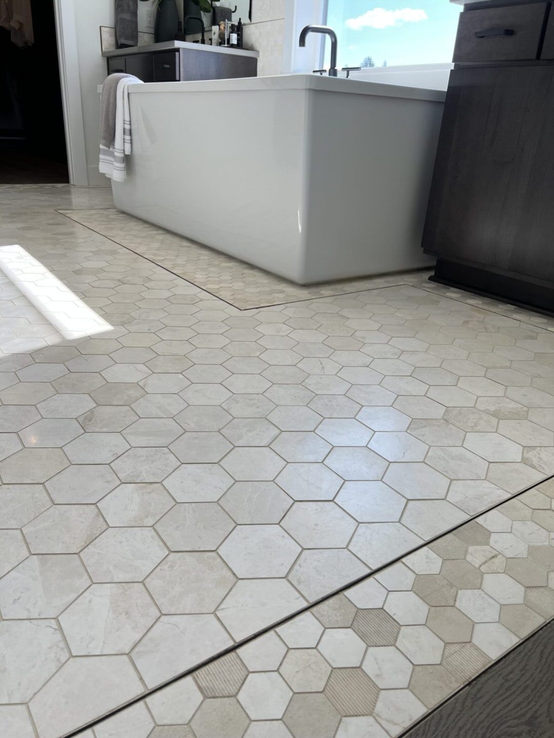 A floor with hexagon tile and tan grout.