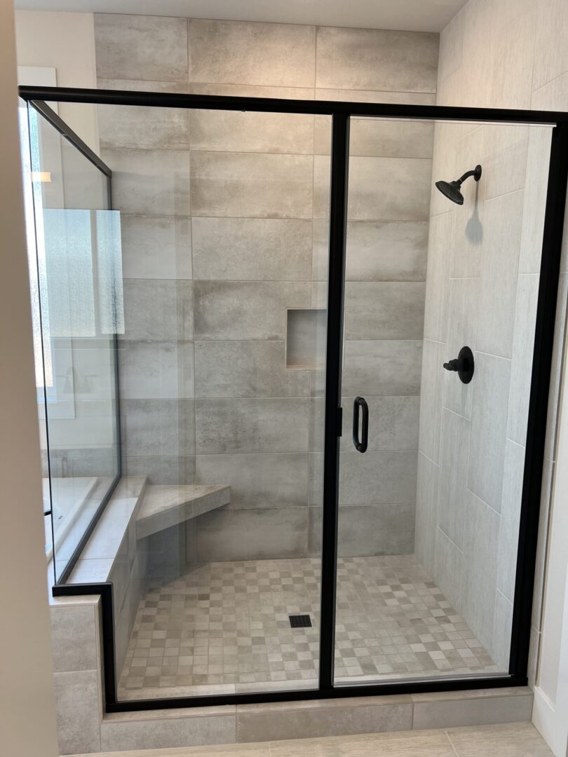 A shower with a bench and tiled walls