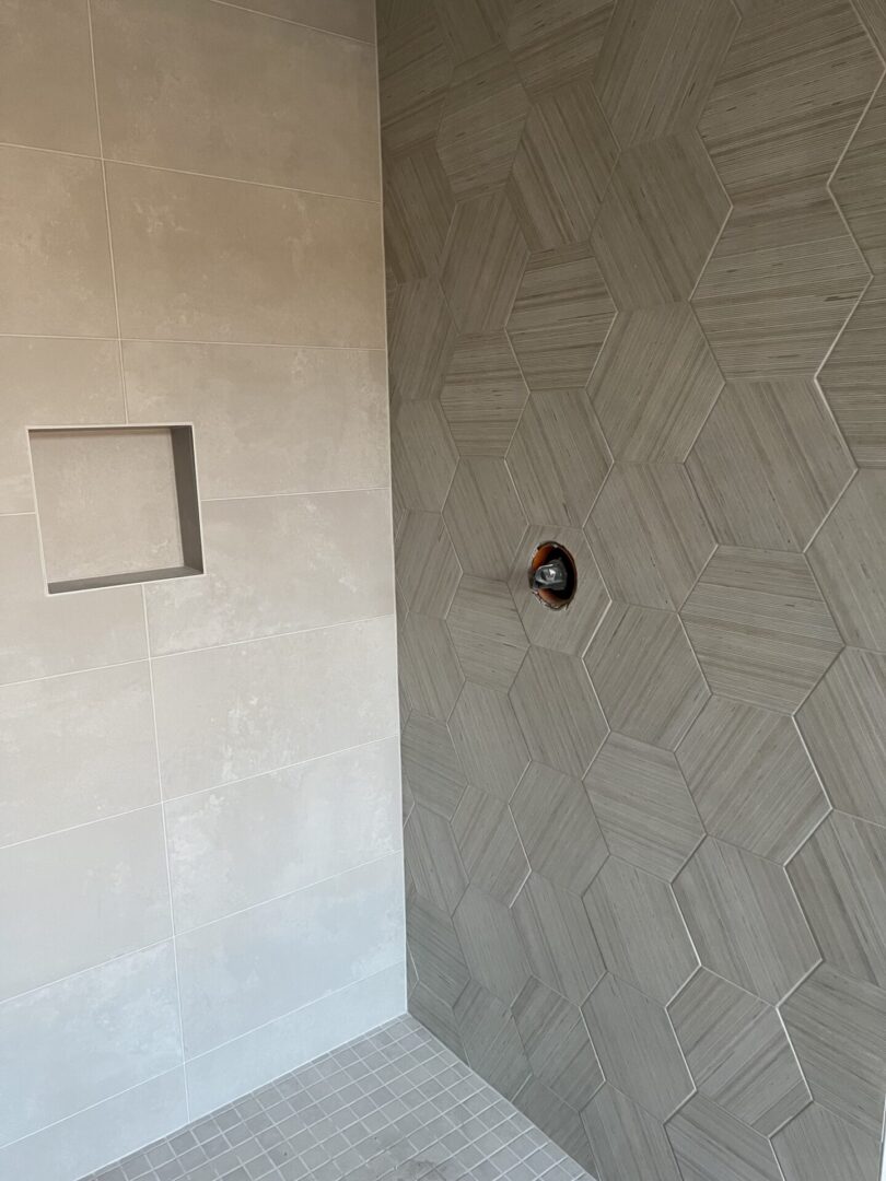 A bathroom with grey tile on walls and floor.